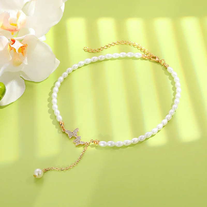 Collier papillon Perles blanches et vol de 2 papillons à strass